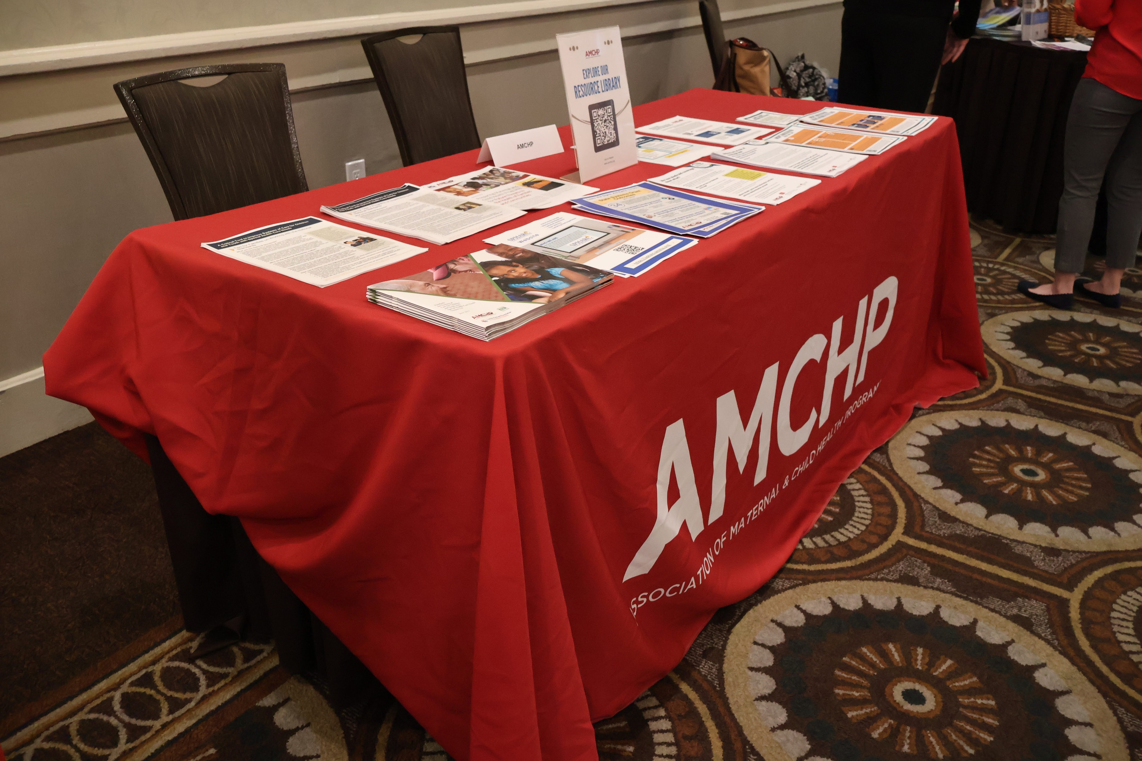 AMCHP exhibitor booth with branded red tablecloth and resource materials